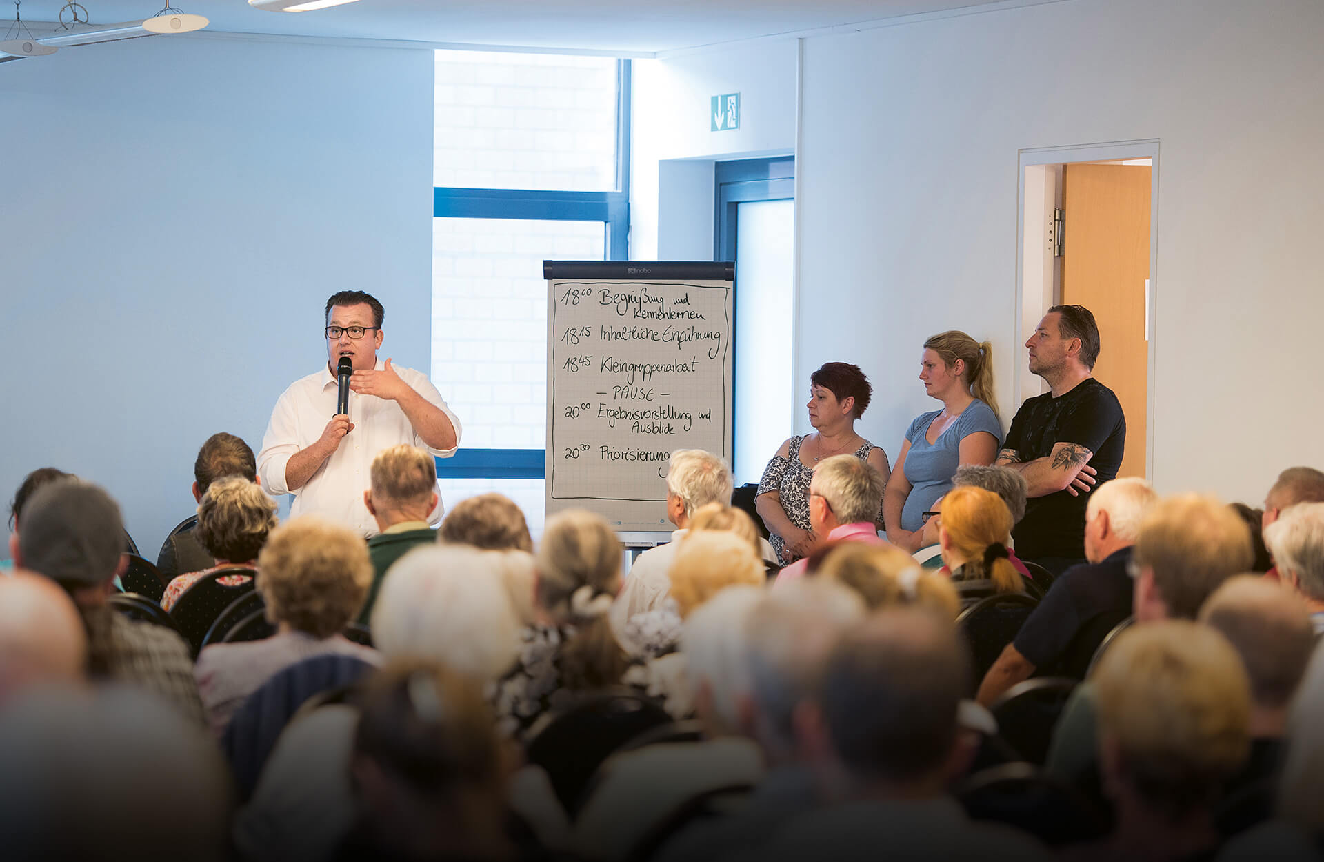 Sebastian Krüger (Regional Area Manager at Vonovia in Berlin) speaking in front of tenants (photo)