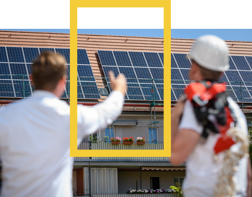 Zwei Menschen mit Solarpanels im Hintergrund (Foto)